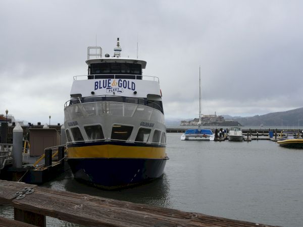 Blue and Gold Fleet ferry docked at Pier 41 with Alcatraz in the distance