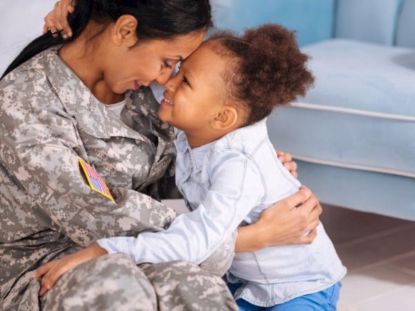 Military service member hugging her child at home