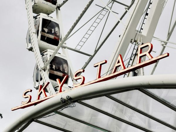 The underside of a tall industrial structure shows red letters &ldquo;SKY IS AIR&rdquo; against the sky.