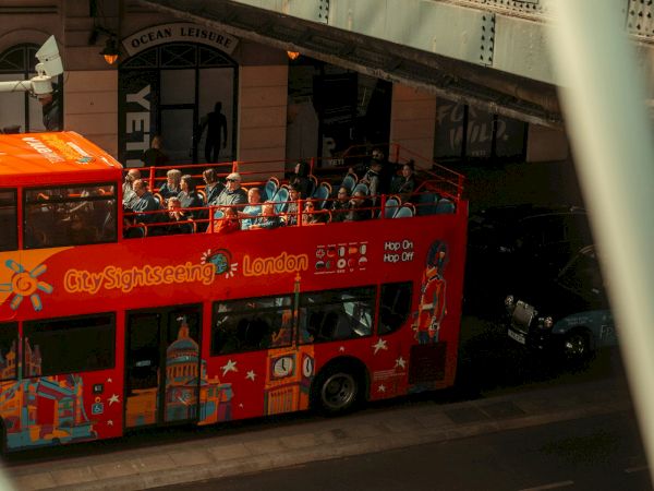 A crowd rides an open-top red double-decker bus in London&rsquo;s &ldquo;Ocean Leisure&rdquo; tunnel at night.